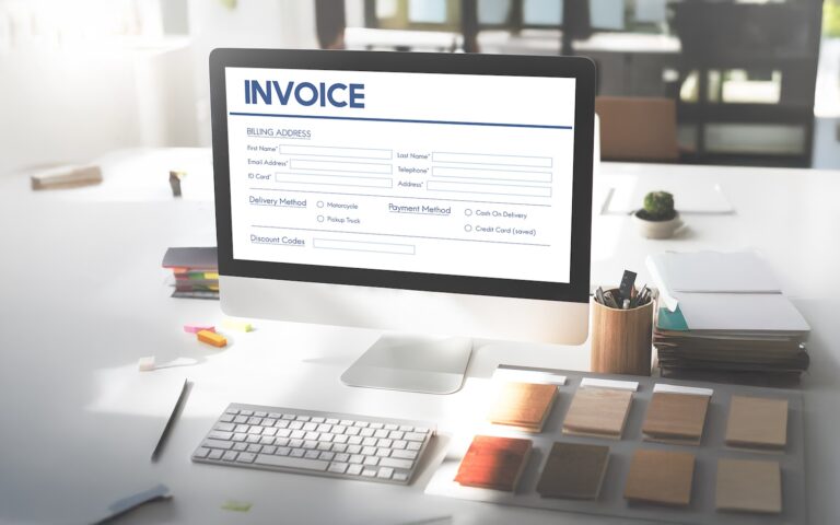 Online invoice processing software displayed on a desktop computer for automated invoice management.